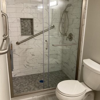 Bathroom remodel with grab bar and glass shower enclosure